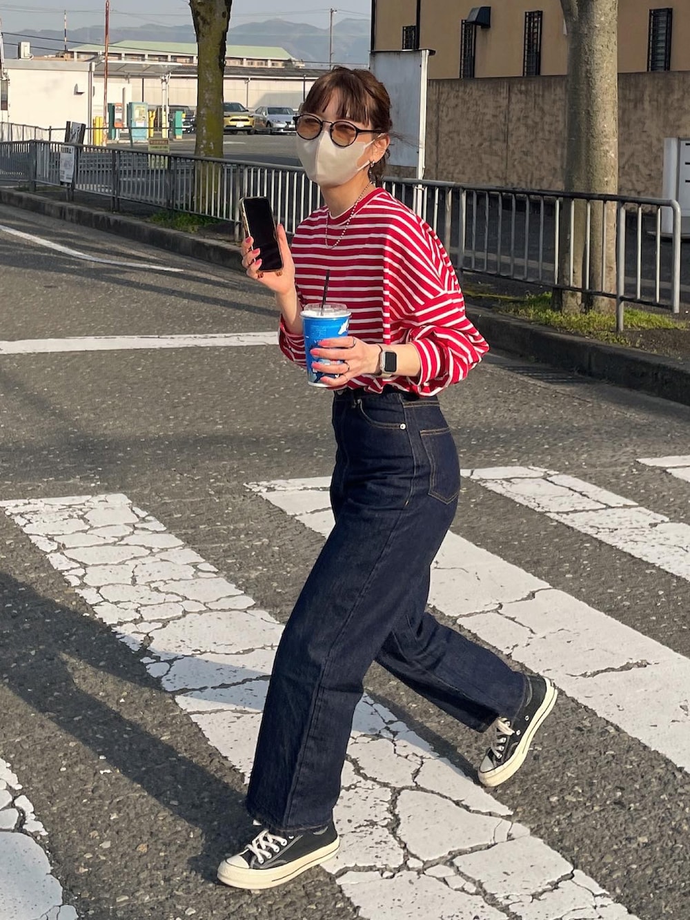 レッド系のTシャツ/カットソー、ブルー系のデニムパンツを着用したレディースの春コーディネートの4枚目の写真