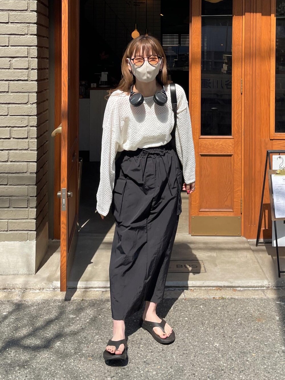 ホワイト系のニット/セーター、ブラック系のスカート、ブラック系のハンドバッグを着用したレディースの春コーディネートの5枚目の写真