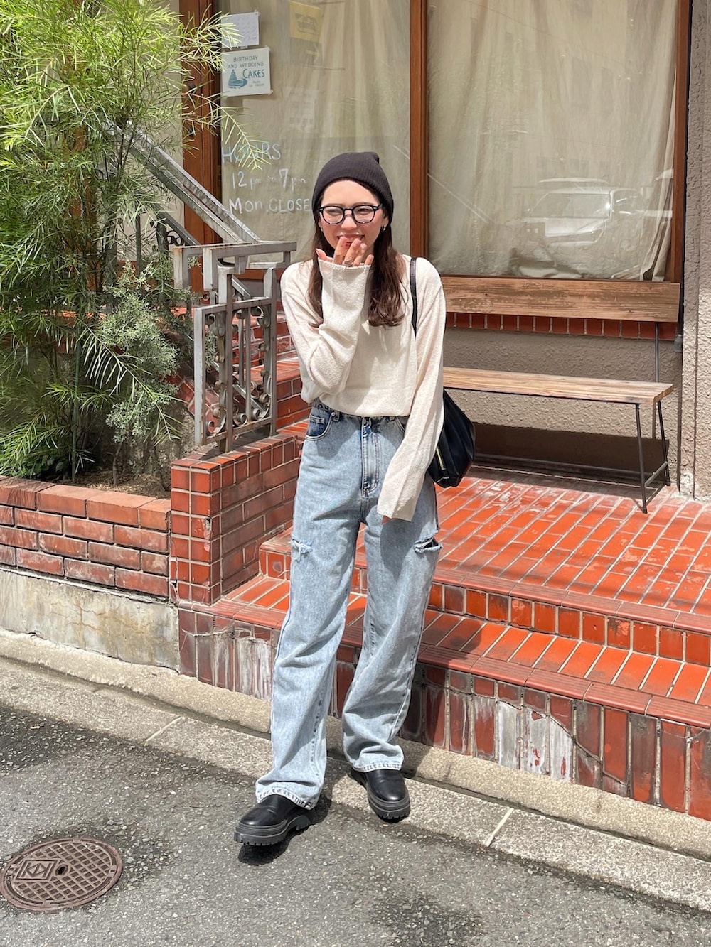 ホワイト系のニット/セーター、ブルー系のデニムパンツ、ブラック系のショルダーバッグを着用したレディースの夏コーディネートの5枚目の写真