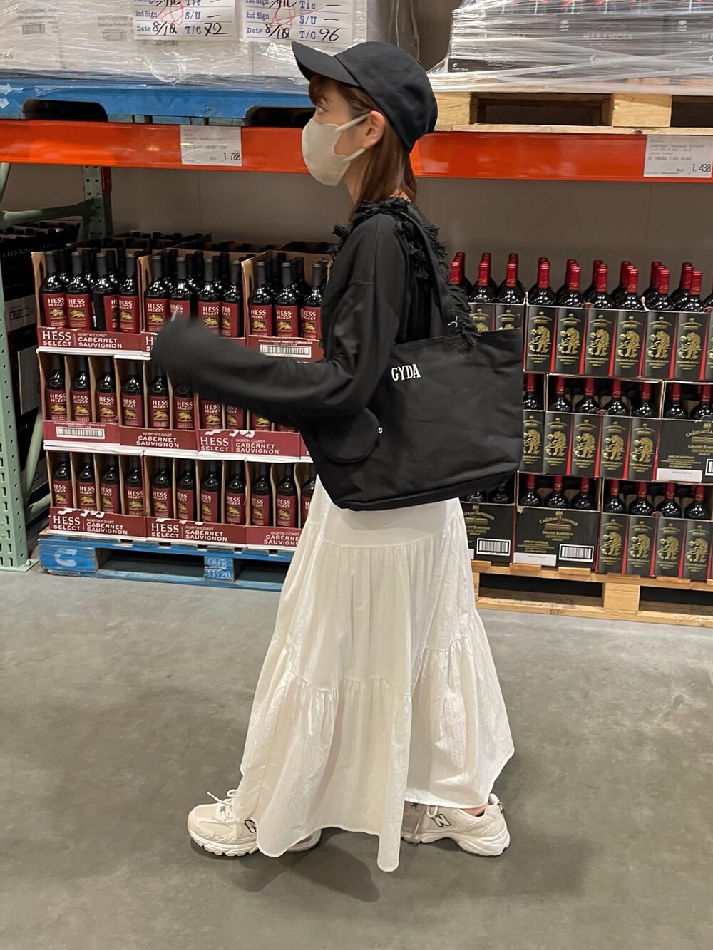 ホワイト系のスカート、ブラック系のトートバッグ、ブラック系のキャップを着用したレディースの夏コーディネートの5枚目の写真