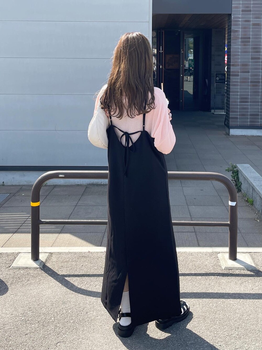 ブラック系のワンピース、ホワイト系のハンドバッグを着用したレディースの春コーディネートの4枚目の写真