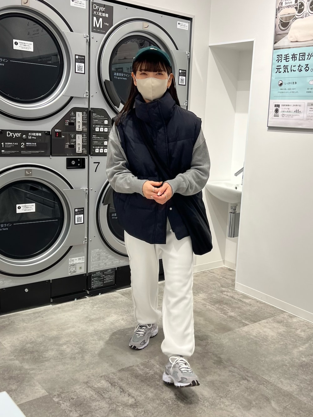 ブラック系のダウンベスト、グレー系のニット/セーター、ホワイト系のその他パンツを着用したレディースの冬コーディネートの4枚目の写真