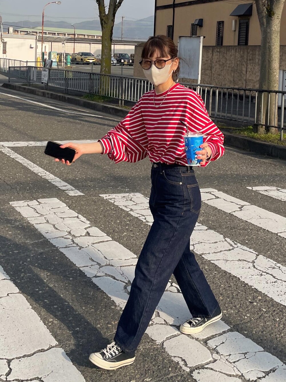 レッド系のTシャツ/カットソー、ブルー系のデニムパンツを着用したレディースの春コーディネートの2枚目の写真