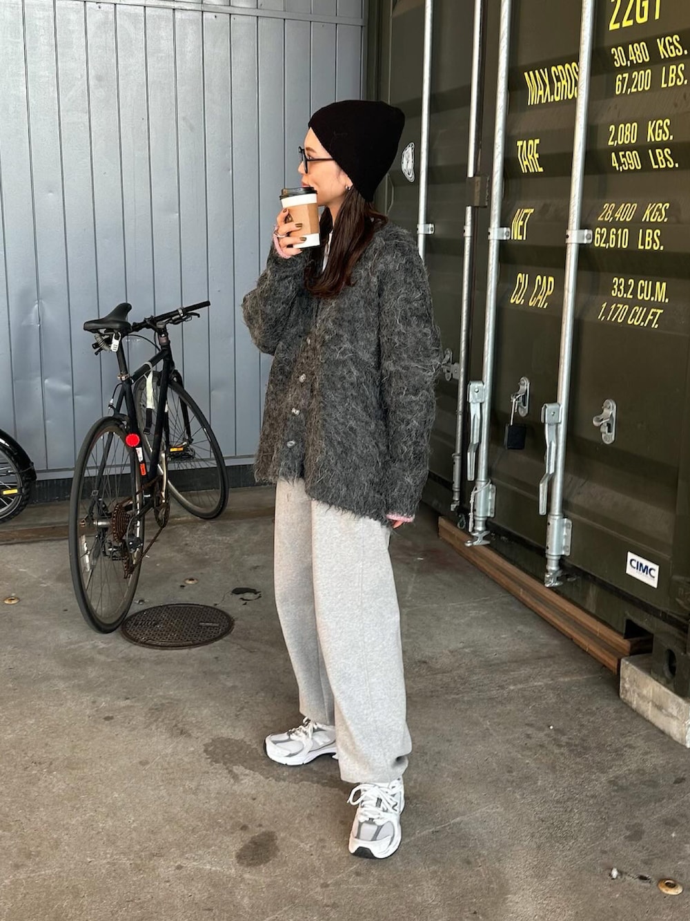 ブラック系のカーディガン/ボレロ、ホワイト系のスニーカー、ブラック系のニットキャップ/ビーニーを着用したレディースの秋コーディネートの2枚目の写真