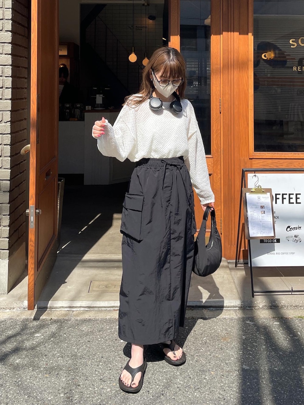 ホワイト系のニット/セーター、ブラック系のスカート、ブラック系のハンドバッグを着用したレディースの春コーディネートの3枚目の写真