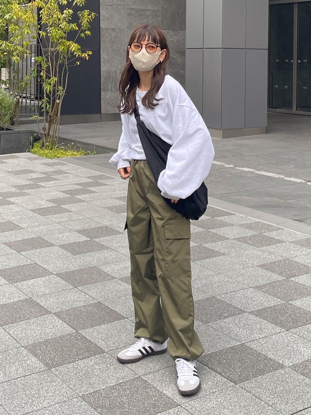 ホワイト系のTシャツ/カットソー、グリーン系のカーゴパンツ、ブラック系のショルダーバッグを着用したレディースの春コーディネートの5枚目の写真