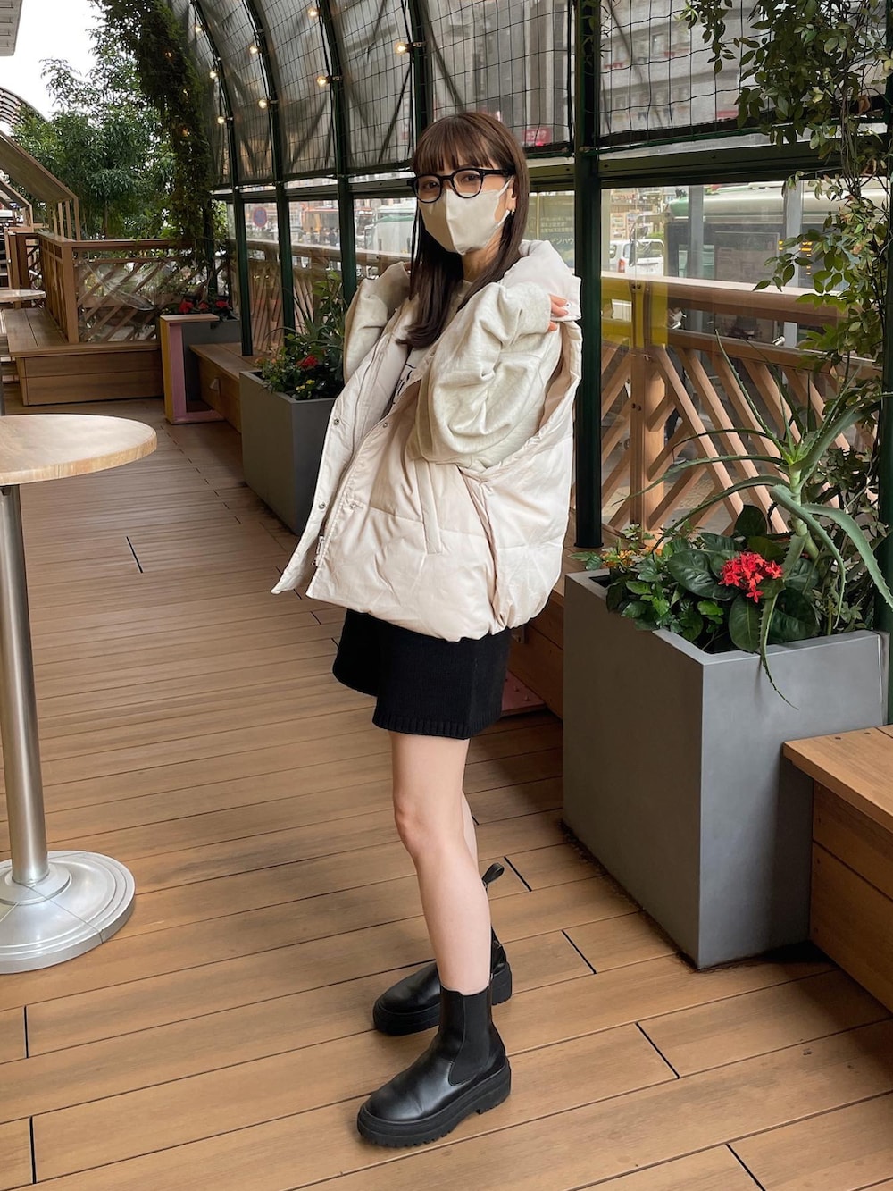 ホワイト系のダウンベスト、ベージュ系のスウェット、ブラック系のその他パンツを着用したレディースの秋コーディネートの3枚目の写真