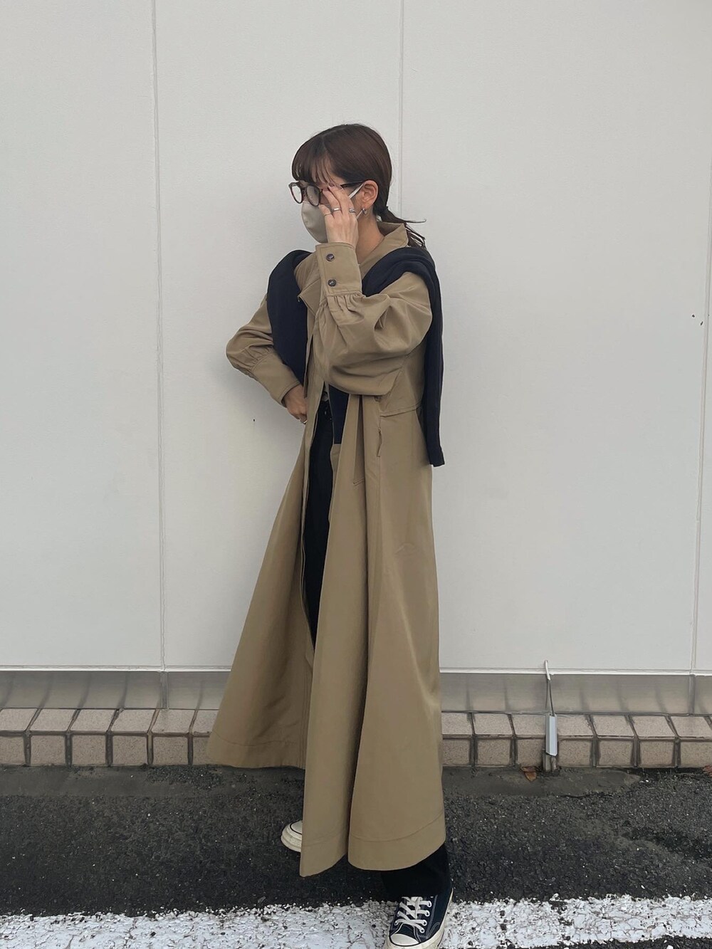 ベージュ系のトレンチコートを着用したレディースの秋コーディネートの3枚目の写真