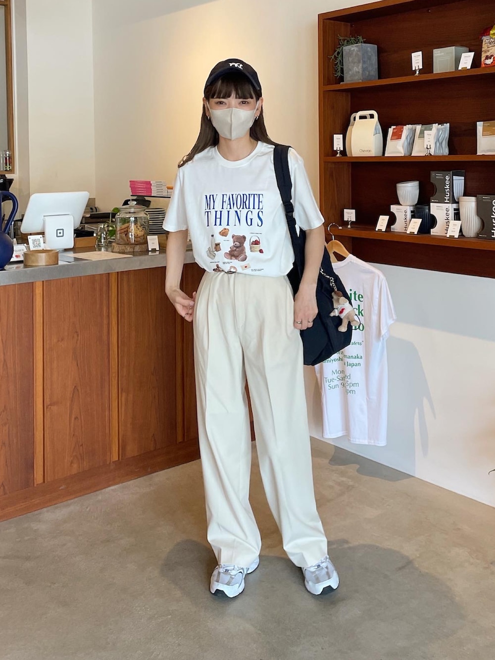ホワイト系のTシャツ/カットソー、ブラック系のバックパック/リュック、ブルー系のキャップを着用したレディースの夏コーディネートの2枚目の写真