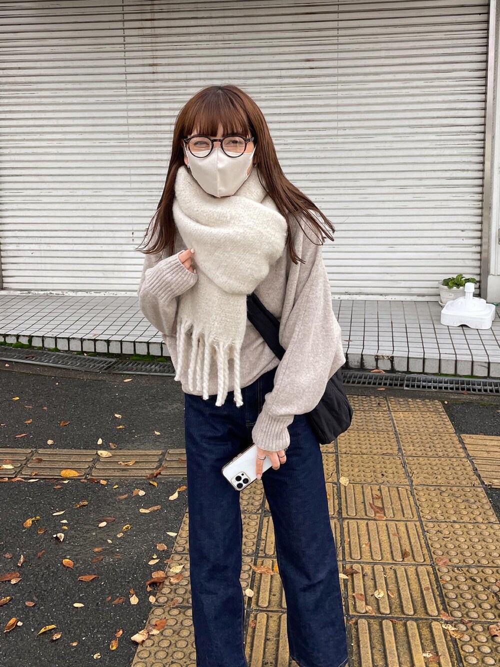 ベージュ系のニット/セーター、ブルー系のデニムパンツを着用したレディースの冬コーディネートの5枚目の写真