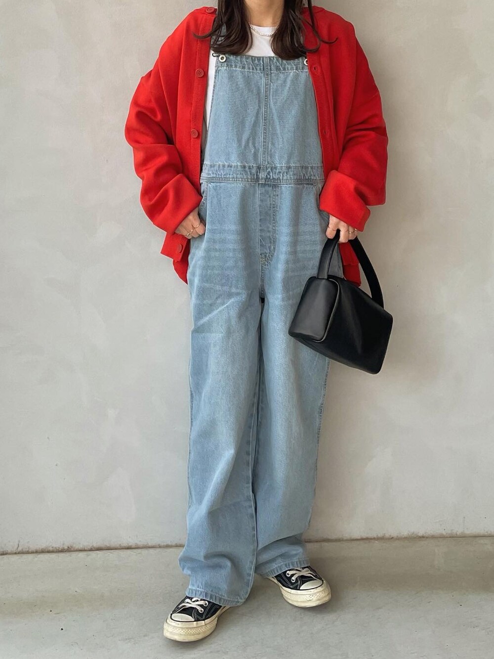 オレンジ系のカーディガン/ボレロ、ブルー系のサロペット/オーバーオールを着用したレディースの冬コーディネートの2枚目の写真