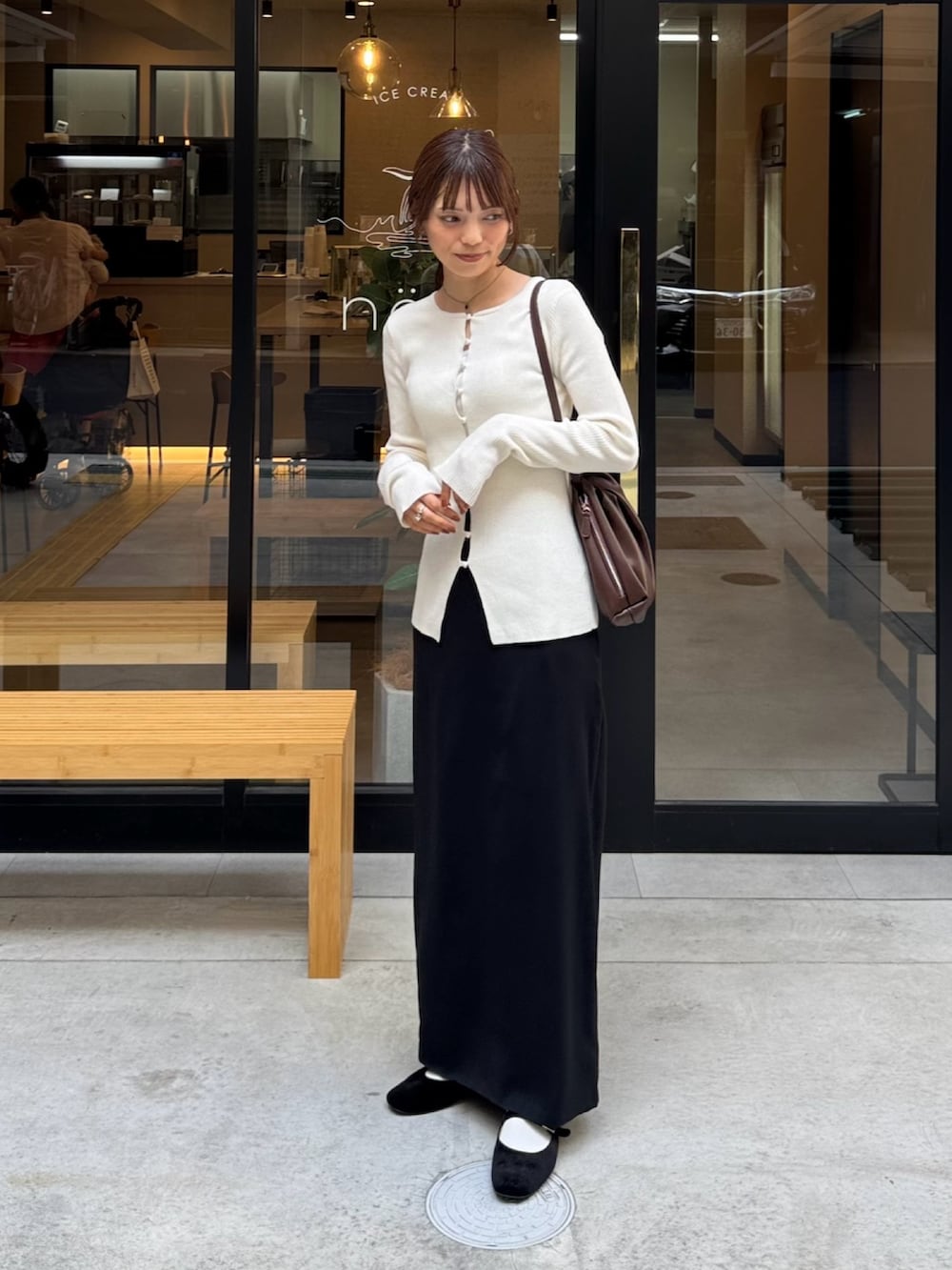 ホワイト系のニット/セーター、ブラック系のスカート、ブラウン系のショルダーバッグを着用したレディースの秋コーディネートの2枚目の写真