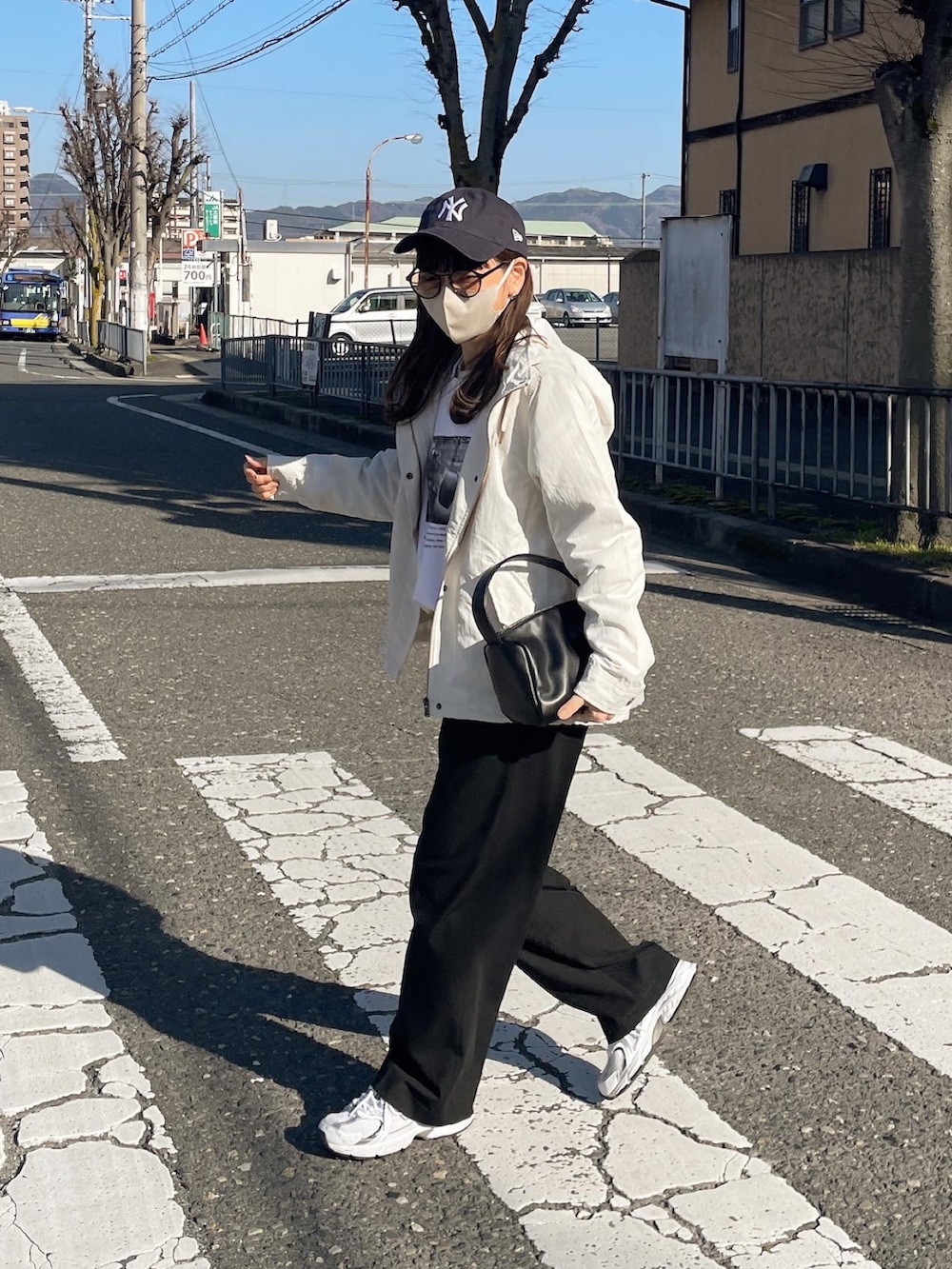 ホワイト系のマウンテンパーカー、ブルー系のキャップを着用したレディースの春コーディネートの5枚目の写真