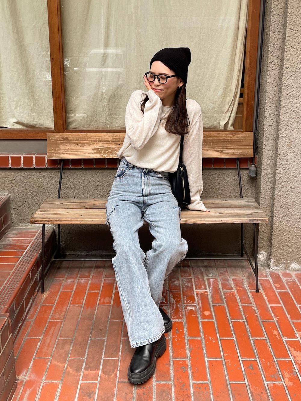 ホワイト系のニット/セーター、ブルー系のデニムパンツ、ブラック系のショルダーバッグを着用したレディースの夏コーディネートの4枚目の写真