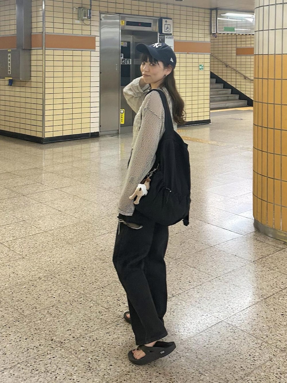 ブラック系のデニムパンツ、ホワイト系のTシャツ/カットソー、ブルー系のキャップを着用したレディースの春コーディネートの4枚目の写真