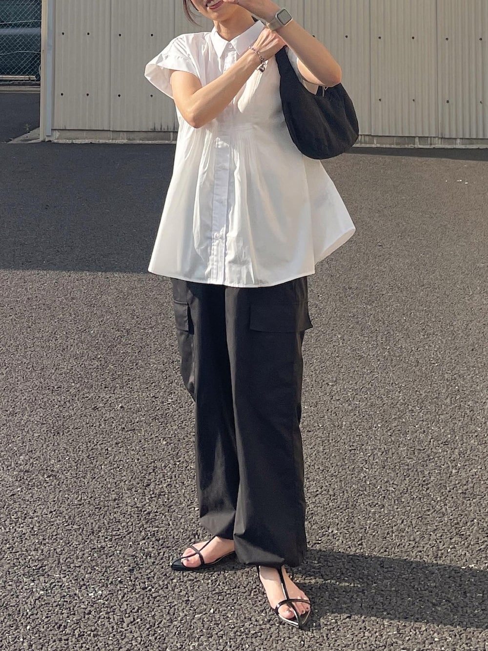 ホワイト系のシャツ/ブラウス、ブラック系のカーゴパンツ、ブラック系のハンドバッグを着用したレディースの夏コーディネートの3枚目の写真