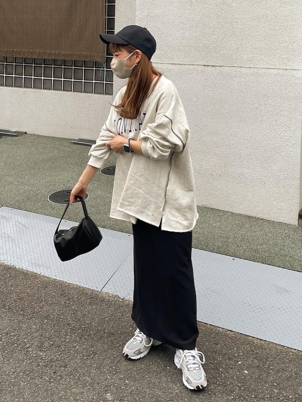 グレー系のスウェット、ブラック系のスカートを着用したレディースの秋コーディネートの2枚目の写真