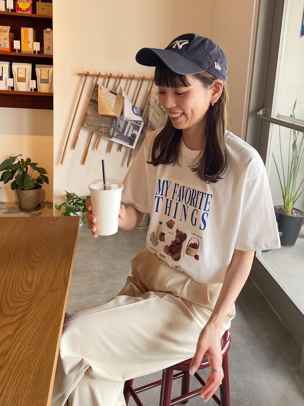 ホワイト系のTシャツ/カットソー、ブラック系のバックパック/リュック、ブルー系のキャップを着用したレディースの夏コーディネートの5枚目の写真
