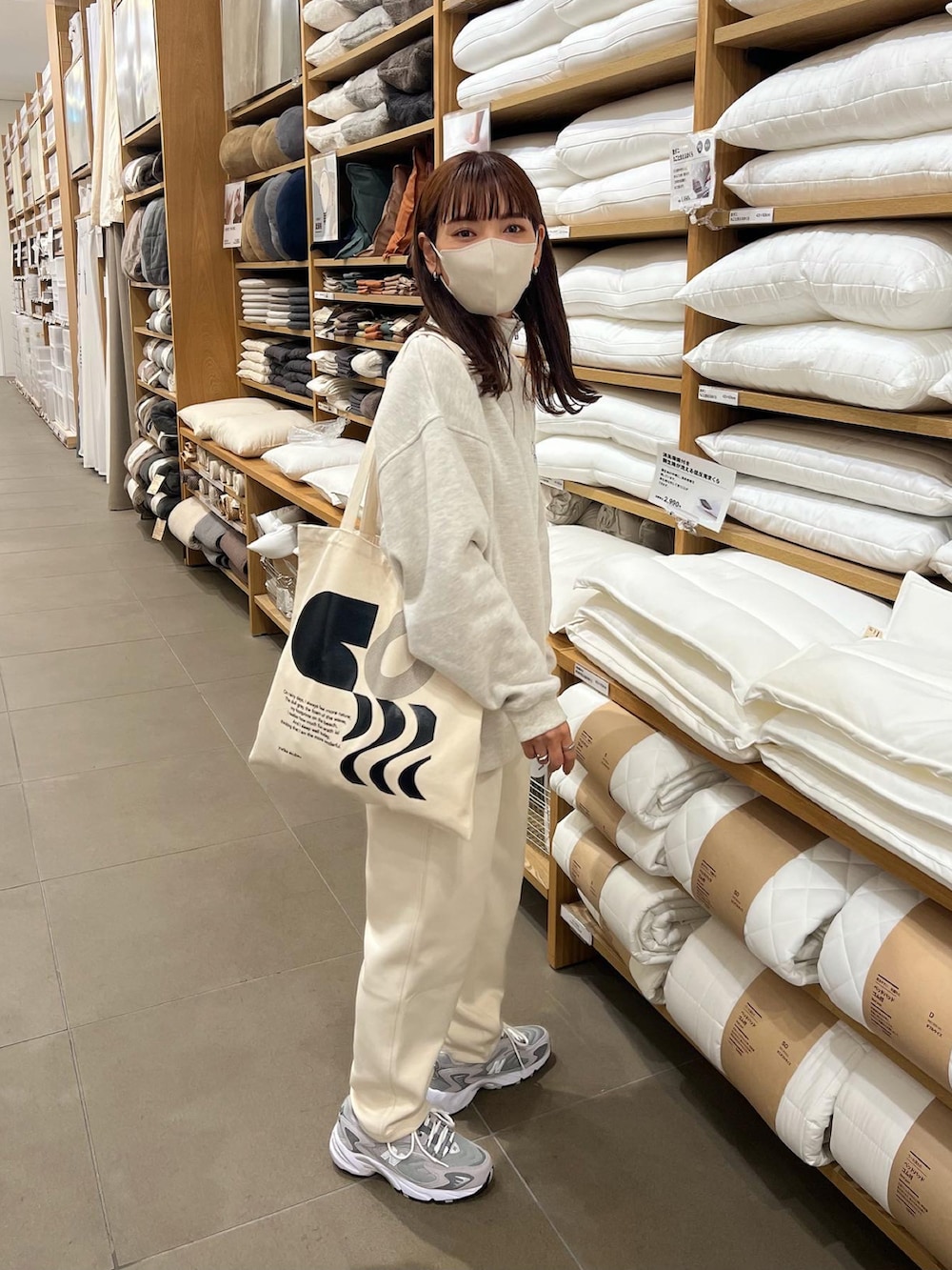 ベージュ系のスウェット、ホワイト系のパンツを着用したレディースの秋コーディネートの5枚目の写真