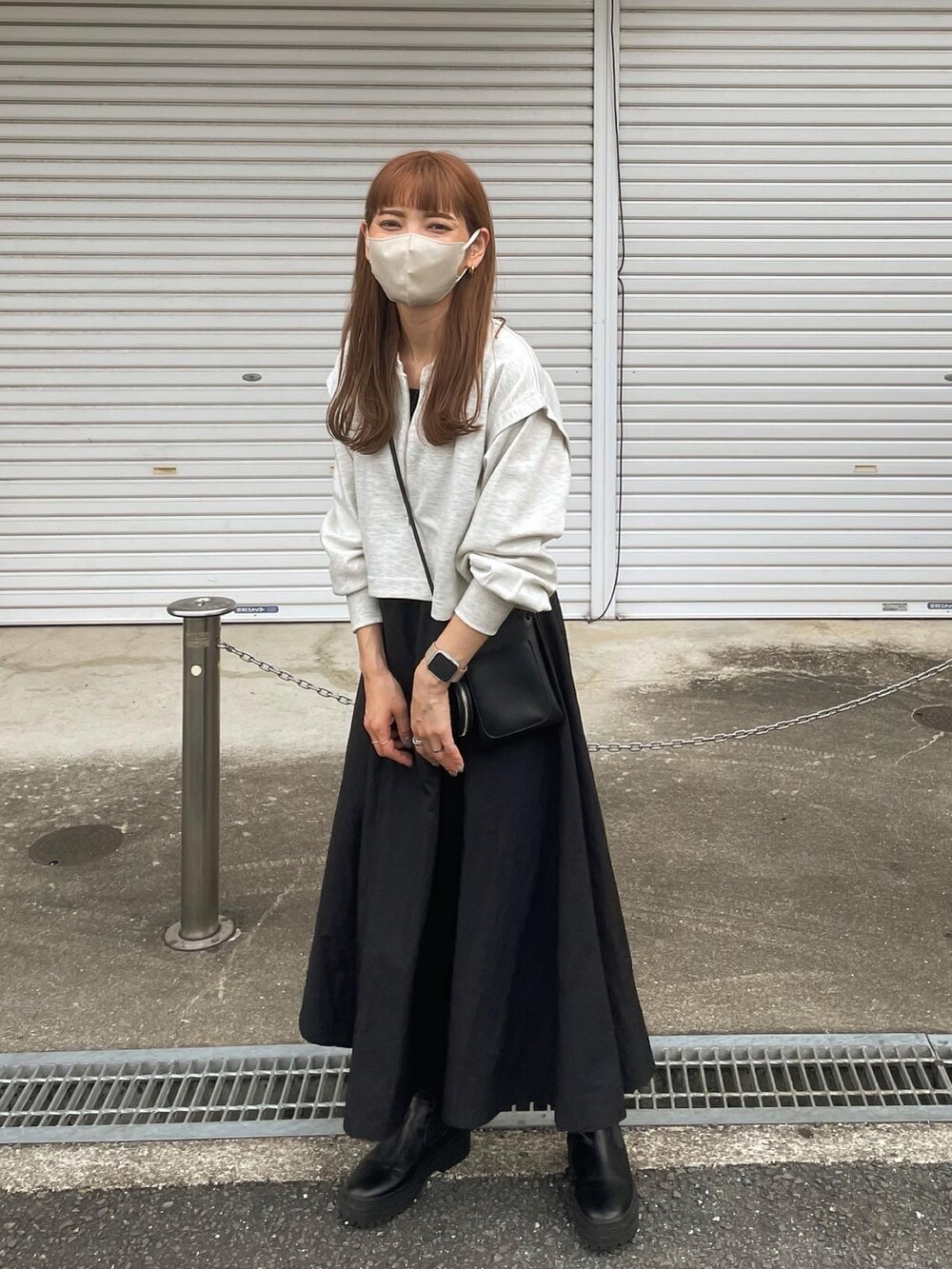 グレー系のワンピース、ブラック系のショルダーバッグ、ブラック系のブーツを着用したレディースの秋コーディネートの4枚目の写真