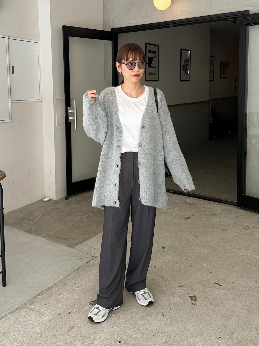 グレー系のカーディガン/ボレロ、グレー系のスラックス、ホワイト系のスニーカーを着用したレディースの秋コーディネートの3枚目の写真