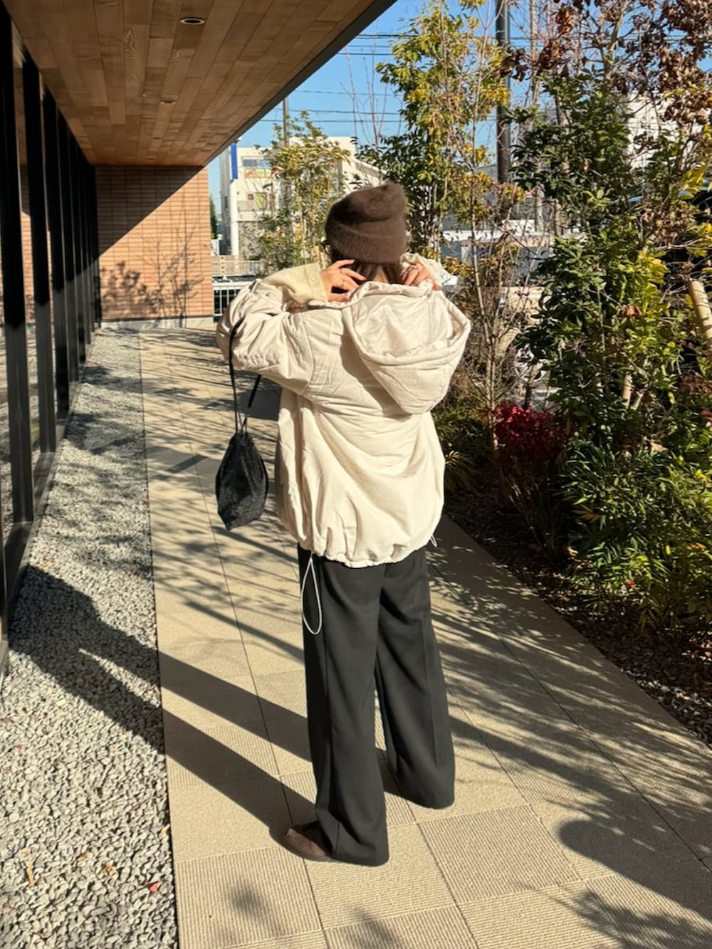 ホワイト系のダウンジャケット/コート、ホワイト系のニット/セーター、ブラック系のショルダーバッグを着用したレディースの冬コーディネートの4枚目の写真