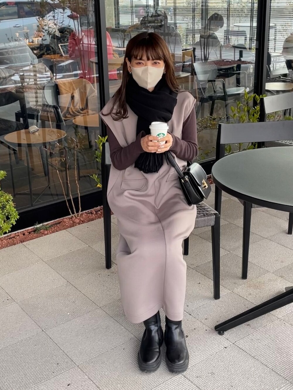 ブラウン系のワンピースを着用したレディースの冬コーディネートの2枚目の写真