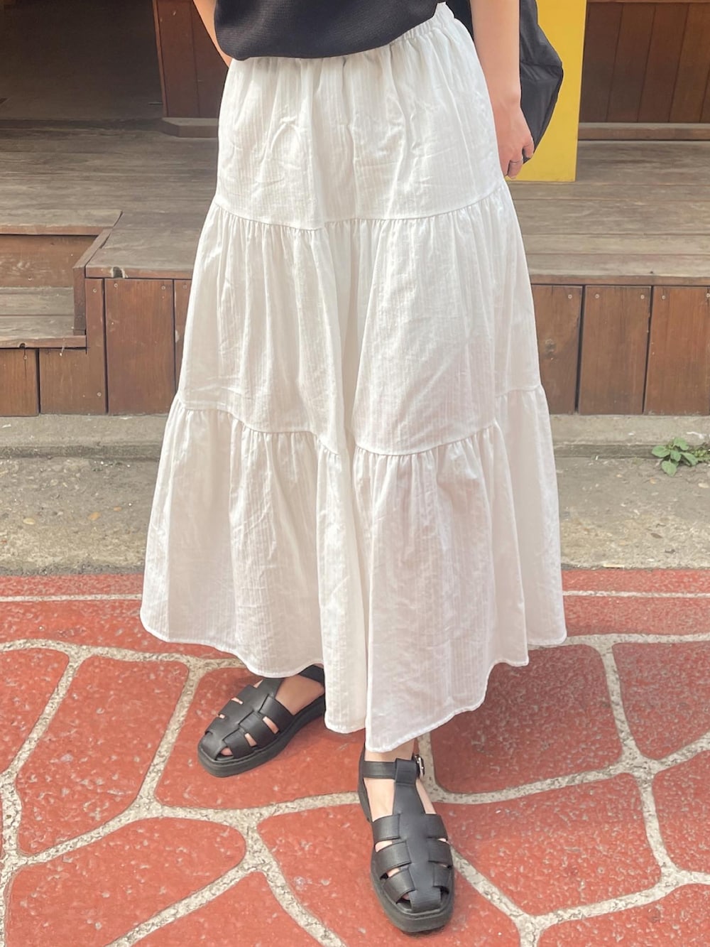 ホワイト系のスカート、ブラック系のその他シューズを着用したレディースの春コーディネートの5枚目の写真