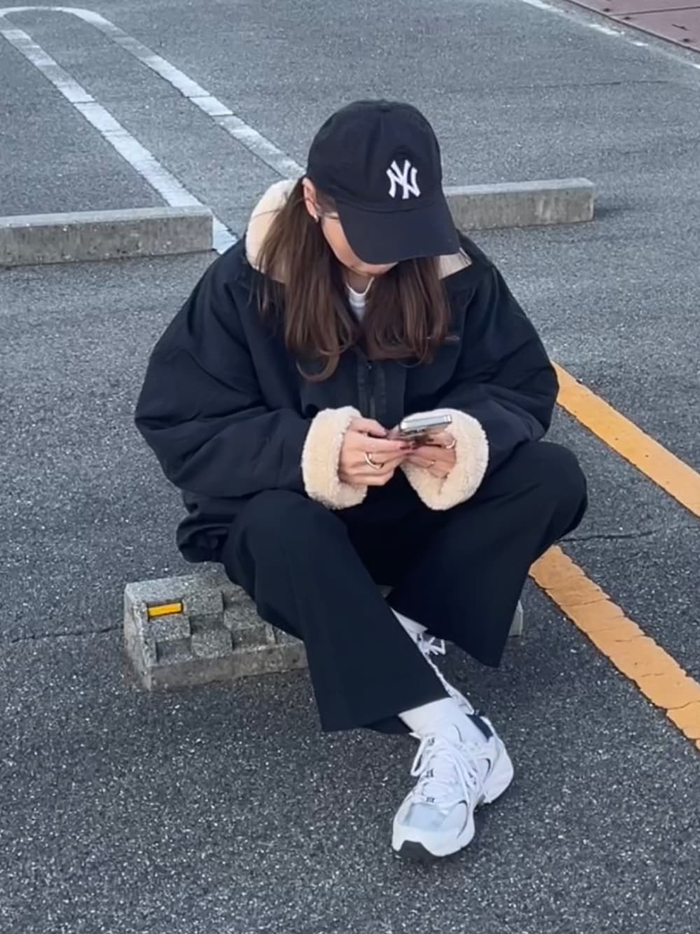 ブラック系のブルゾン、ブルー系のキャップを着用したレディースの秋コーディネートの3枚目の写真