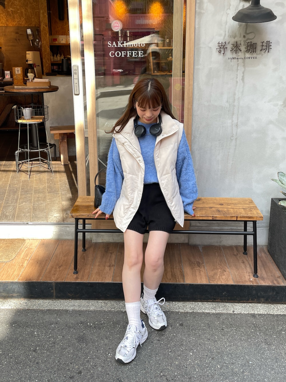 ブルー系のニット/セーター、ホワイト系のダウンベスト、ブラック系のその他パンツを着用したレディースの秋コーディネートの3枚目の写真