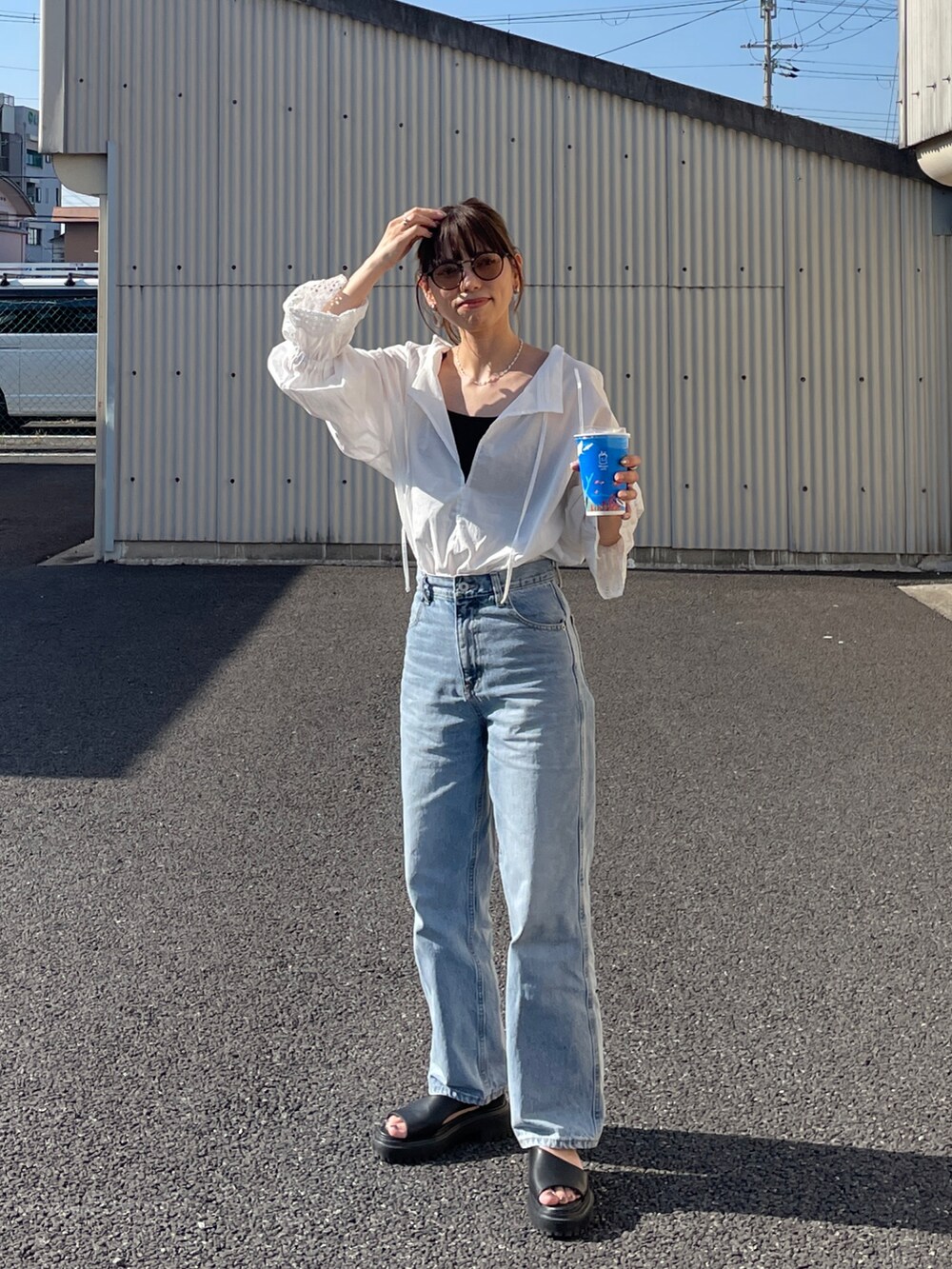 ホワイト系のシャツ/ブラウス、ブルー系のデニムパンツ、シルバー系のネックレスを着用したレディースの春コーディネートの3枚目の写真