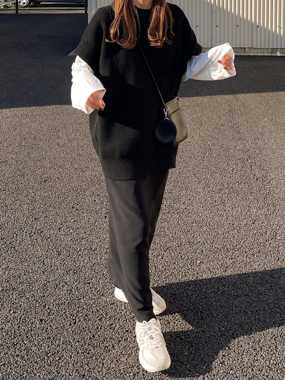 ブラック系のベスト、ホワイト系のTシャツ/カットソー、ブラック系のスカートを着用したレディースの秋コーディネートの3枚目の写真