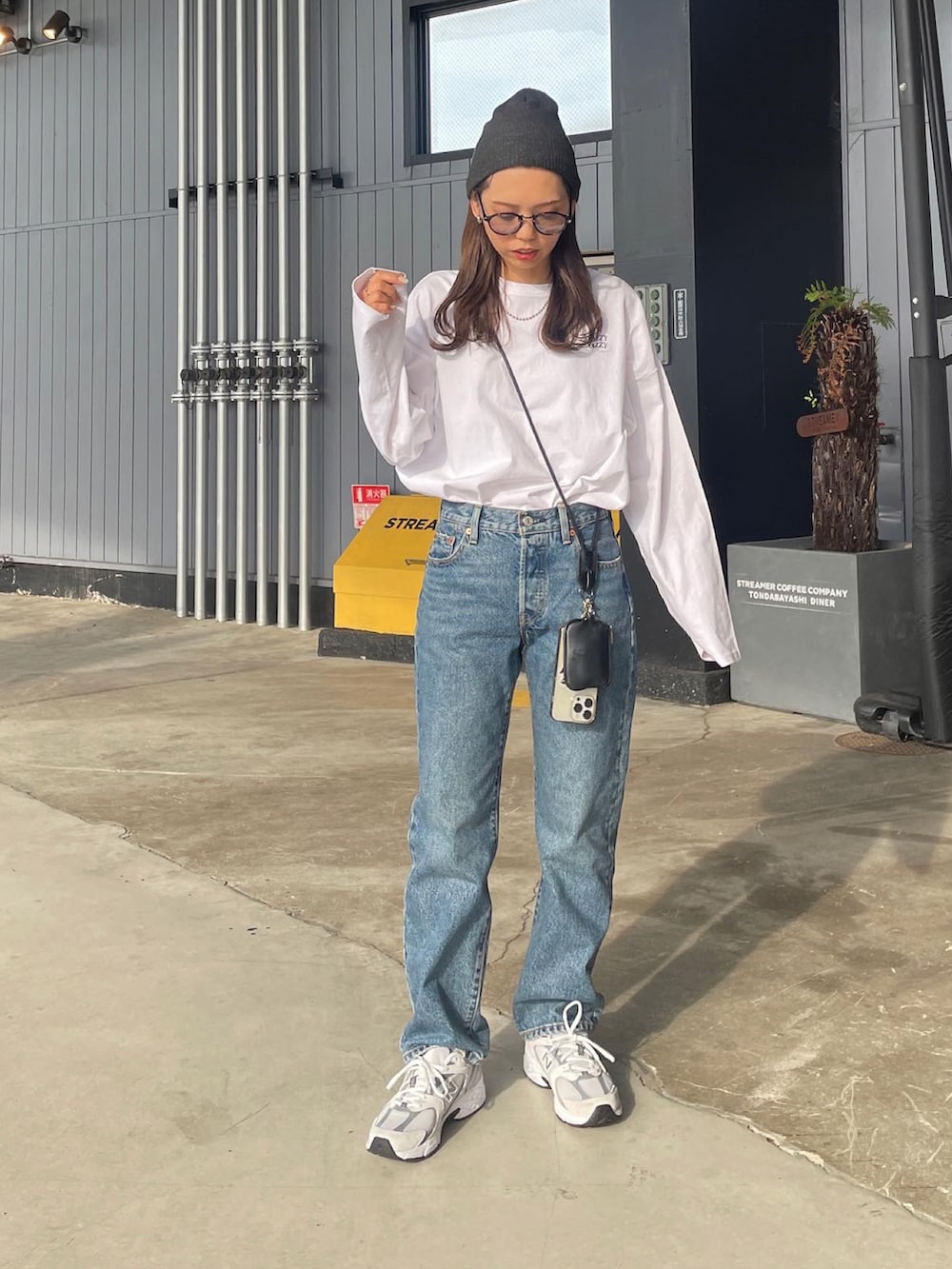 ホワイト系のTシャツ/カットソー、ブルー系のデニムパンツ、ホワイト系のスニーカーを着用したレディースの秋コーディネートの4枚目の写真