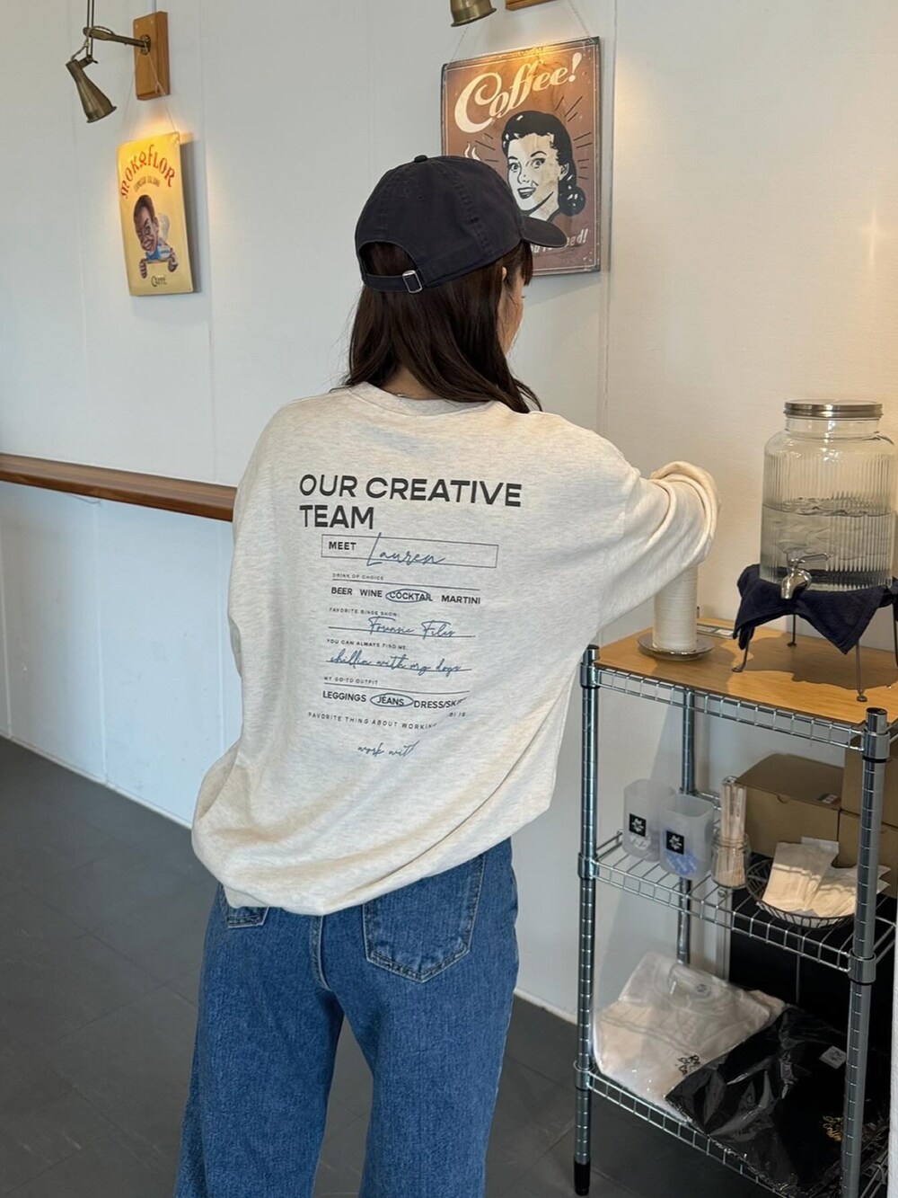 ホワイト系のスウェット、ブルー系のデニムパンツ、ブラック系のスニーカーを着用したレディースの春コーディネートの3枚目の写真