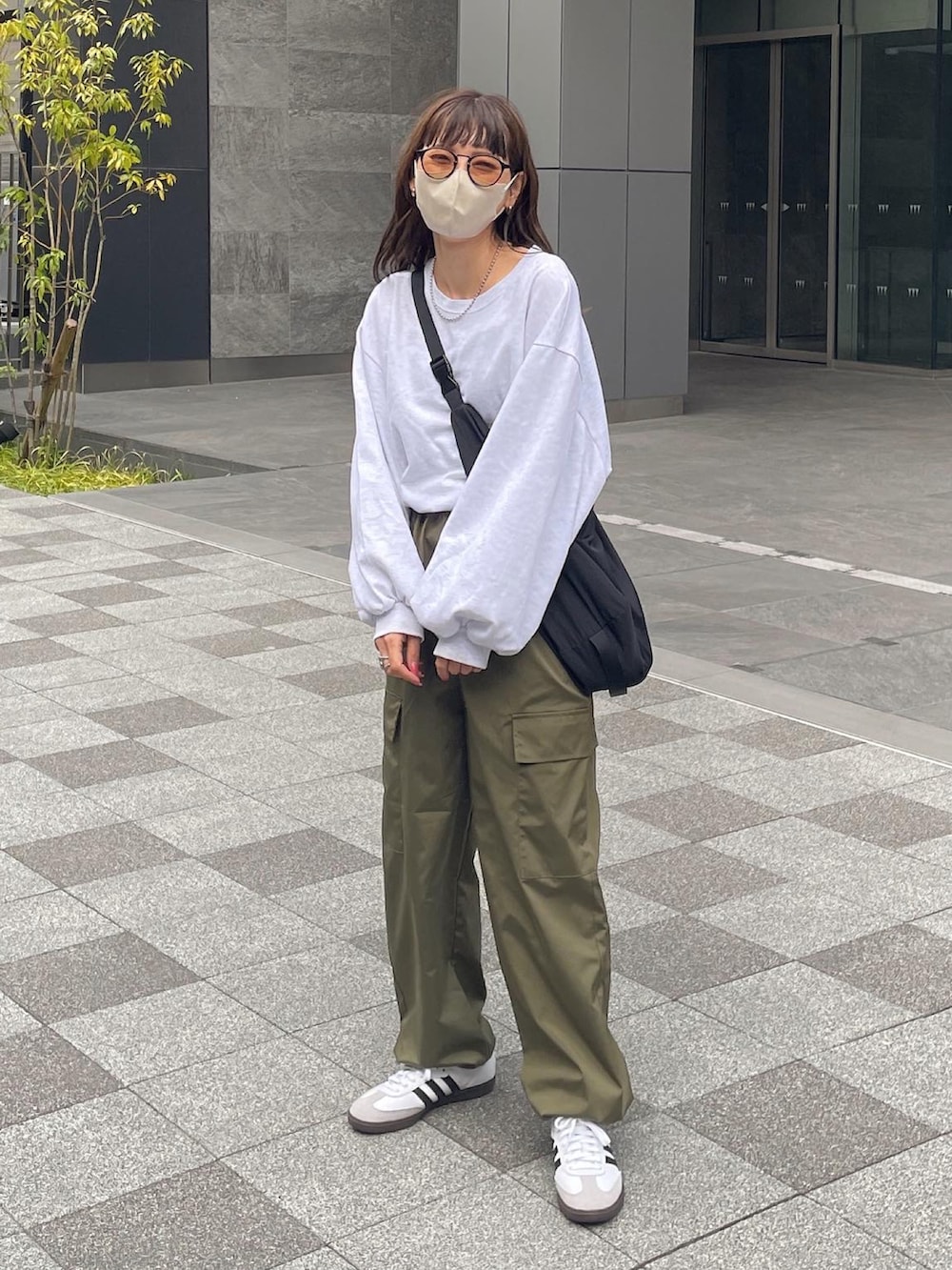 ホワイト系のTシャツ/カットソー、グリーン系のカーゴパンツ、ブラック系のショルダーバッグを着用したレディースの春コーディネートの2枚目の写真