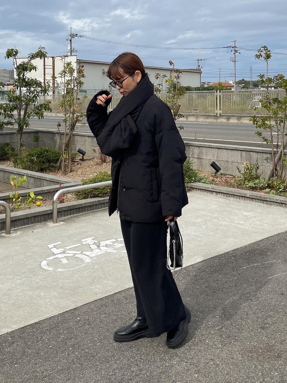 ブラック系のダウンジャケット/コート、ブラック系のスカート、ブラック系のショルダーバッグを着用したレディースの秋コーディネートの2枚目の写真