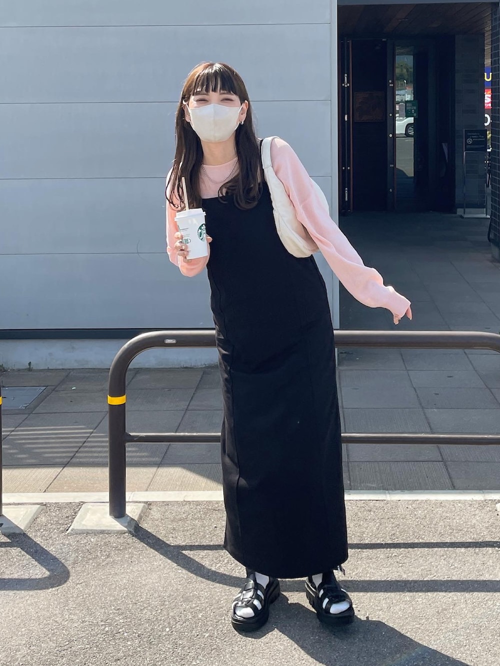 ブラック系のワンピース、ホワイト系のハンドバッグを着用したレディースの春コーディネートの3枚目の写真