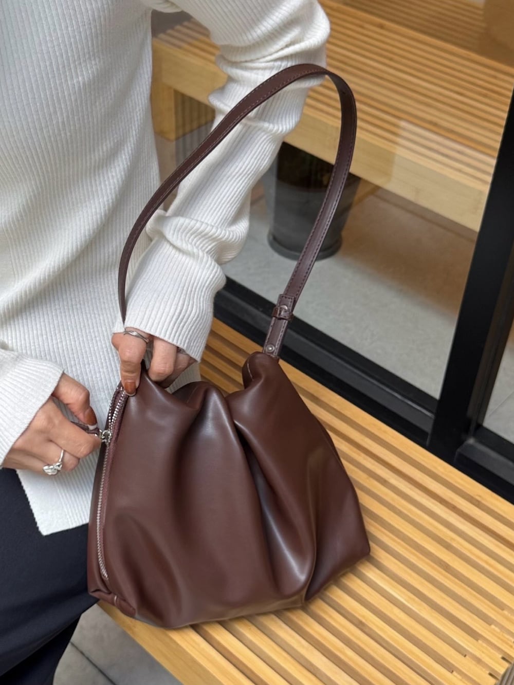 ホワイト系のニット/セーター、ブラック系のスカート、ブラウン系のショルダーバッグを着用したレディースの秋コーディネートの3枚目の写真