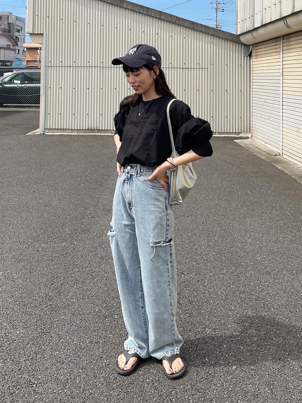 ブラック系のシャツ/ブラウス、ブルー系のデニムパンツ、シルバー系のショルダーバッグを着用したレディースの夏コーディネートの5枚目の写真