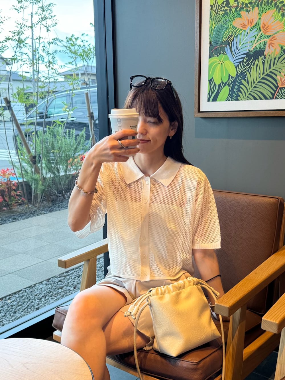 ホワイト系のカーディガン/ボレロ、ホワイト系のショルダーバッグ、ベージュ系のその他パンツを着用したレディースの夏コーディネートの2枚目の写真