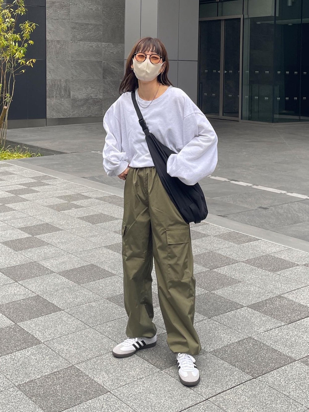 ホワイト系のTシャツ/カットソー、グリーン系のカーゴパンツ、ブラック系のショルダーバッグを着用したレディースの春コーディネートの4枚目の写真