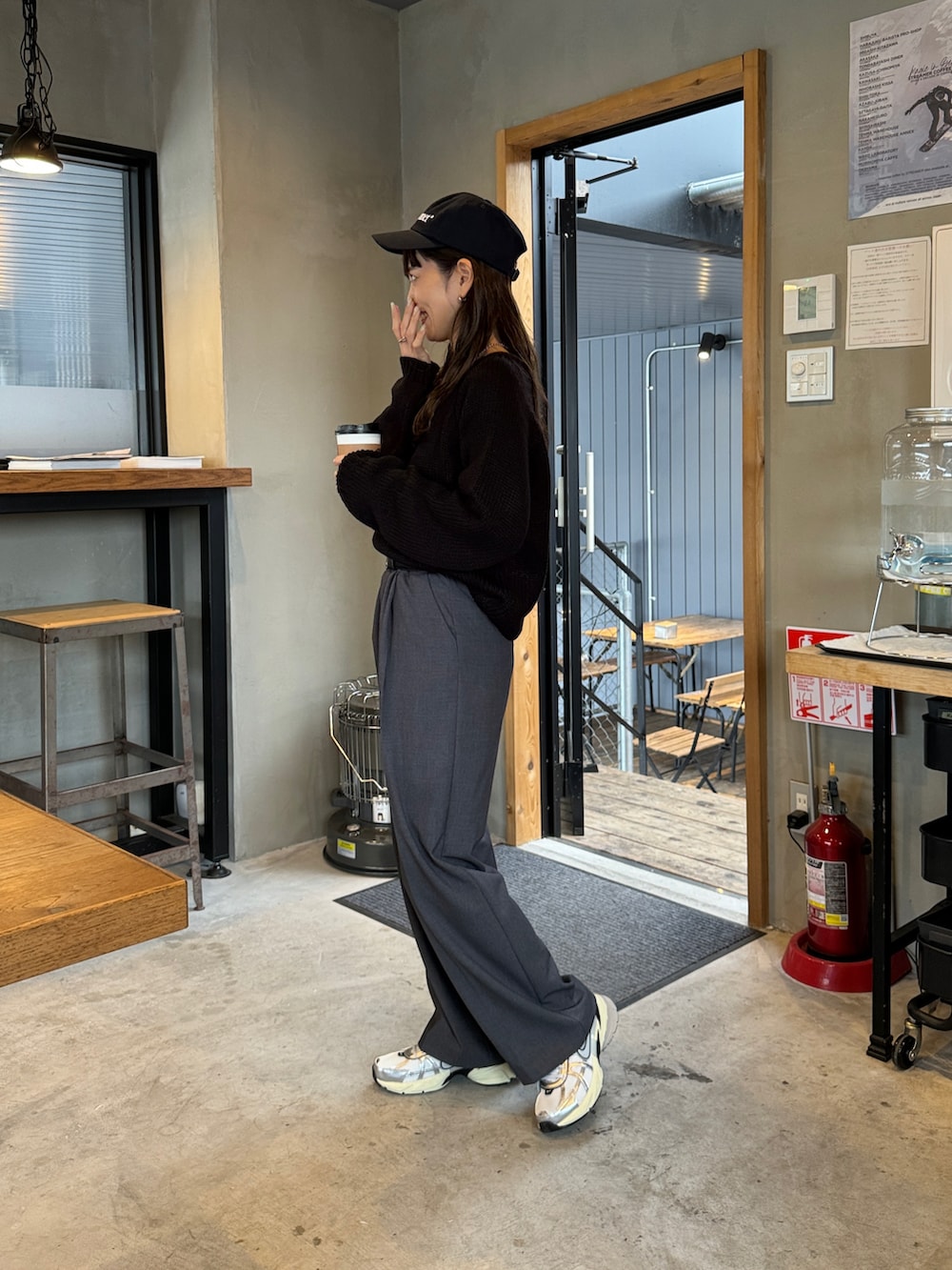 ブラック系のニット/セーター、グレー系のスラックス、ホワイト系のスニーカーを着用したレディースの冬コーディネートの2枚目の写真