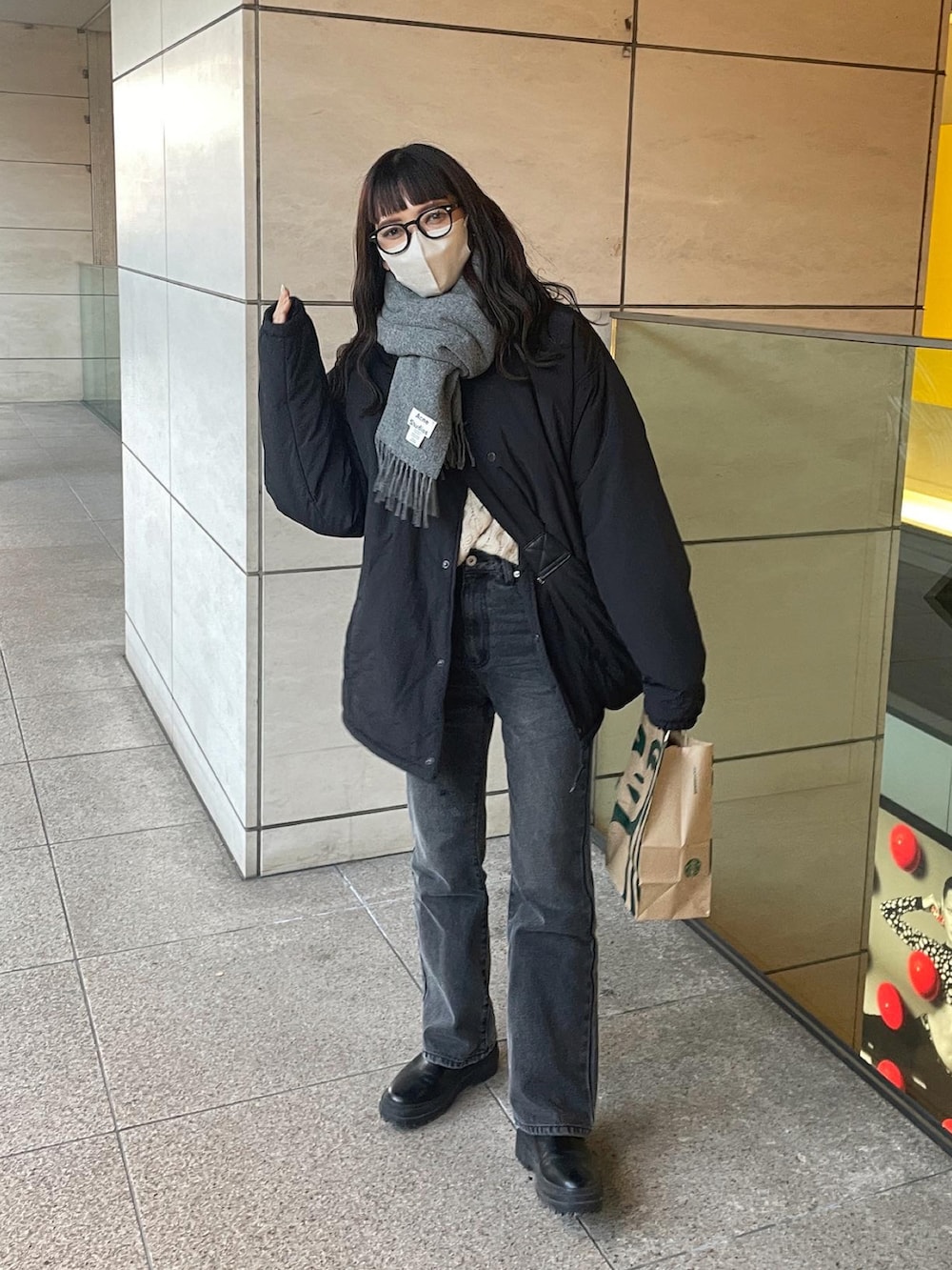 ブラック系のブルゾン、ブラック系のデニムパンツ、ブラック系のショルダーバッグを着用したレディースの冬コーディネートの4枚目の写真