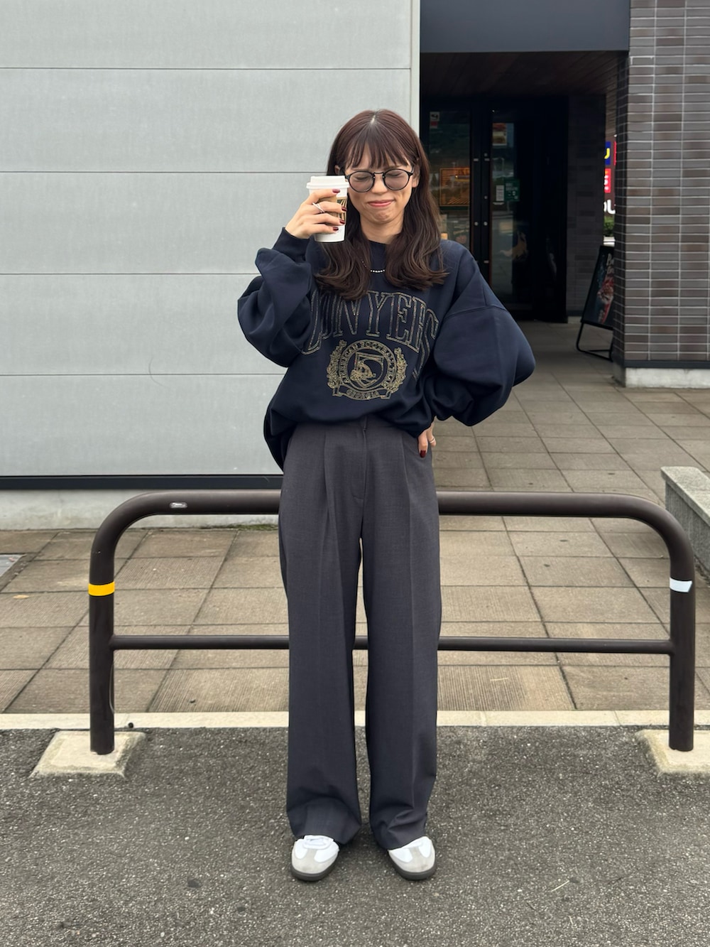 ブルー系のスウェット、グレー系のスラックス、ホワイト系のスニーカーを着用したレディースの秋コーディネートの3枚目の写真