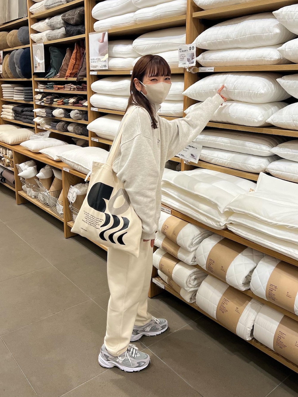 ベージュ系のスウェット、ホワイト系のパンツを着用したレディースの秋コーディネートの3枚目の写真