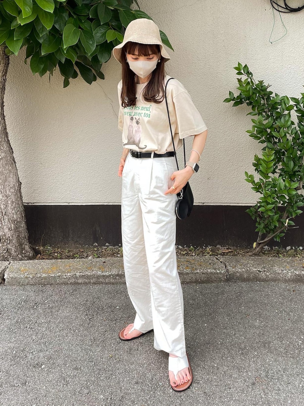 ベージュ系のTシャツ/カットソー、ブラック系のショルダーバッグ、ホワイト系のサンダルを着用したレディースの夏コーディネートの2枚目の写真