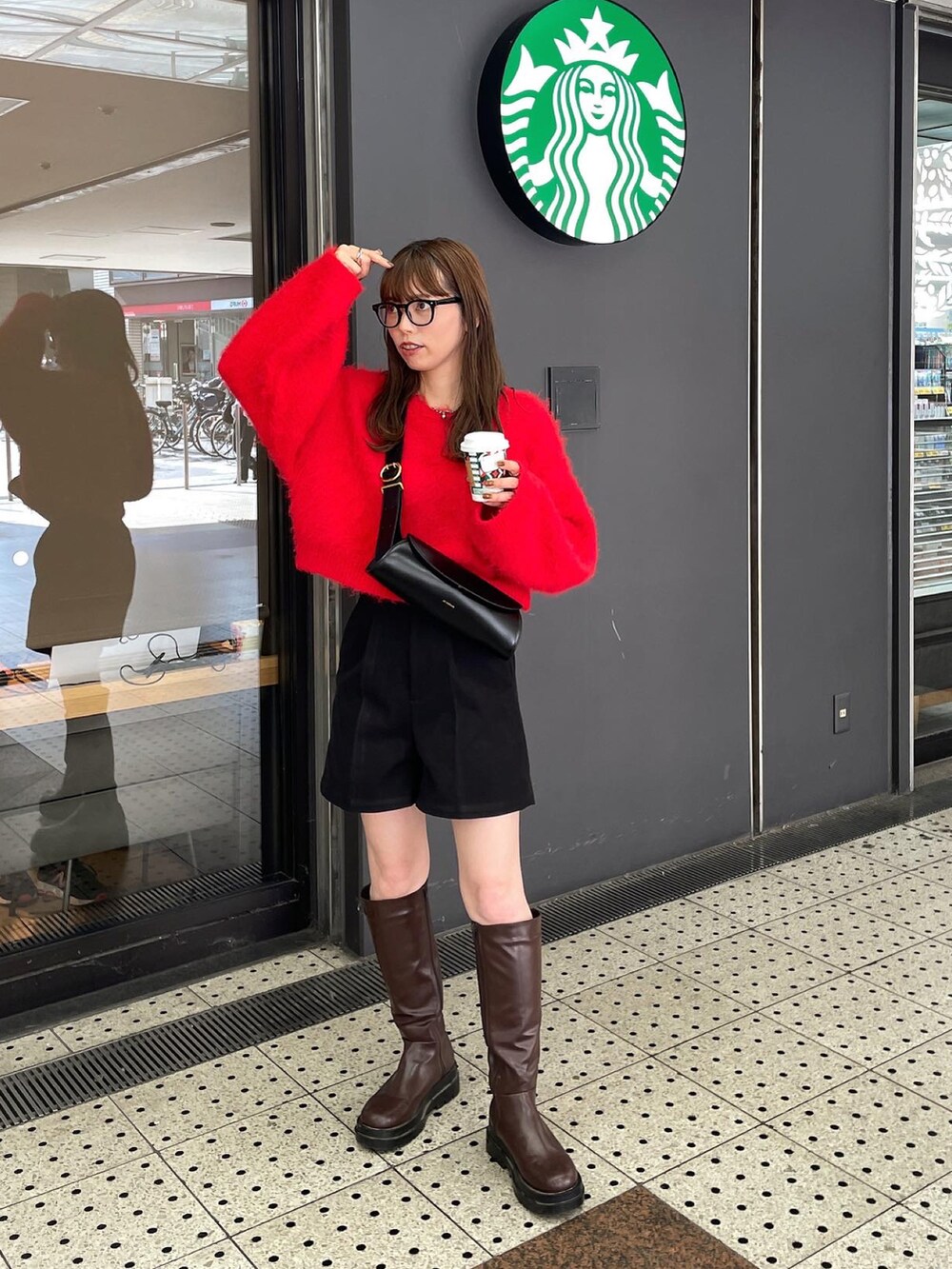 レッド系のニット/セーター、ブラック系のその他パンツ、ブラウン系のブーツを着用したレディースの秋コーディネートの4枚目の写真