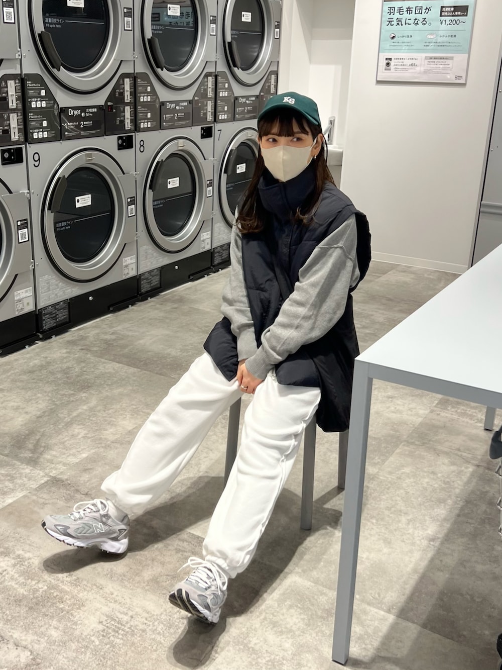 ブラック系のダウンベスト、グレー系のニット/セーター、ホワイト系のその他パンツを着用したレディースの冬コーディネートの3枚目の写真