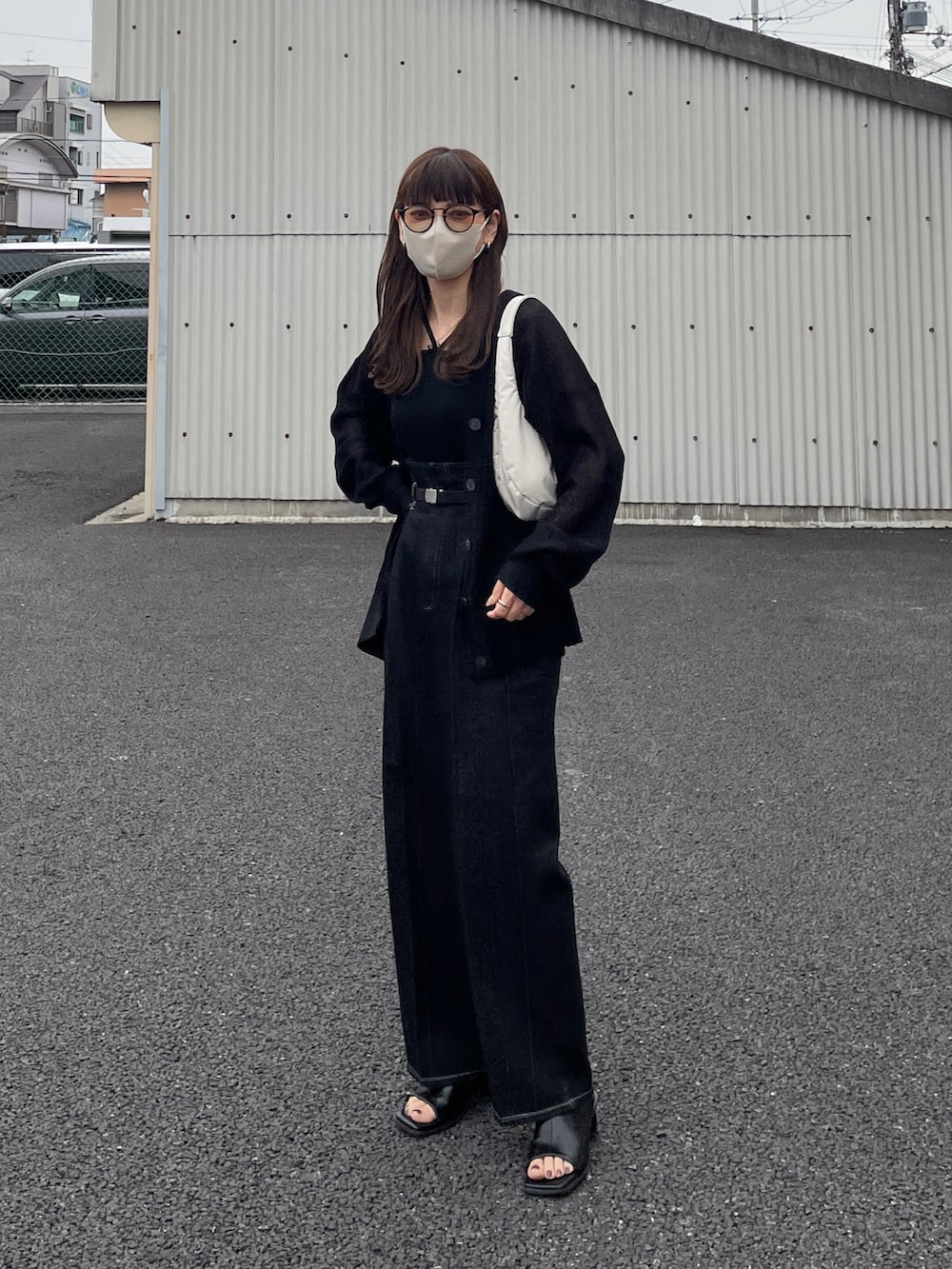 ブラック系のカーディガン/ボレロ、ブラック系のデニムパンツ、ホワイト系のハンドバッグを着用したレディースの春コーディネートの4枚目の写真