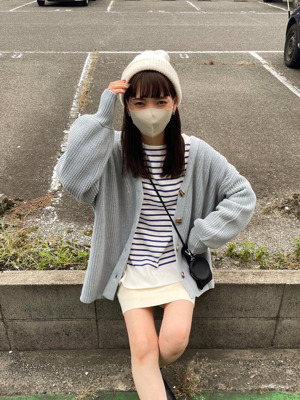 ブルー系のカーディガン/ボレロ、ホワイト系のスカート、ブラック系のショルダーバッグを着用したレディースの秋コーディネートの3枚目の写真